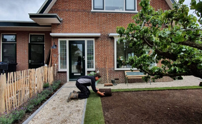 Hovenier Marccuna tijdens het leggen van graszoden