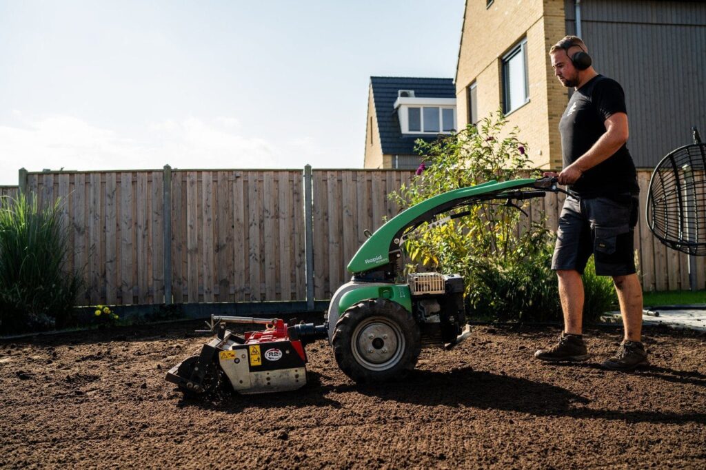 Man freest de bodem van de tuin als voorbereiding voor graszoden