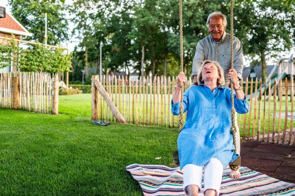 Vrouw op schommel in een tuin met graszoden
