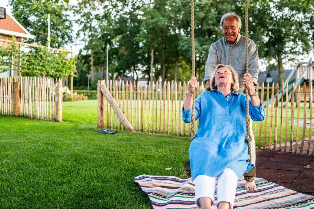 Vrouw op schommel in een tuin met graszoden