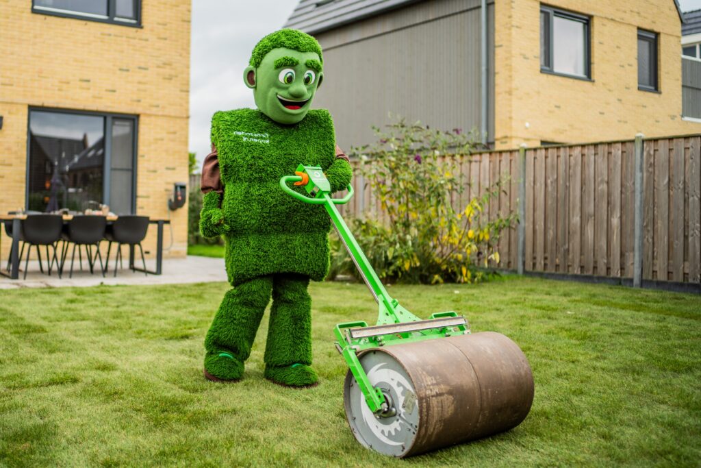 Grasmattie rolt vers gelegde graszoden aan met een gazonwals voor optimale aansluiting met de bodem.