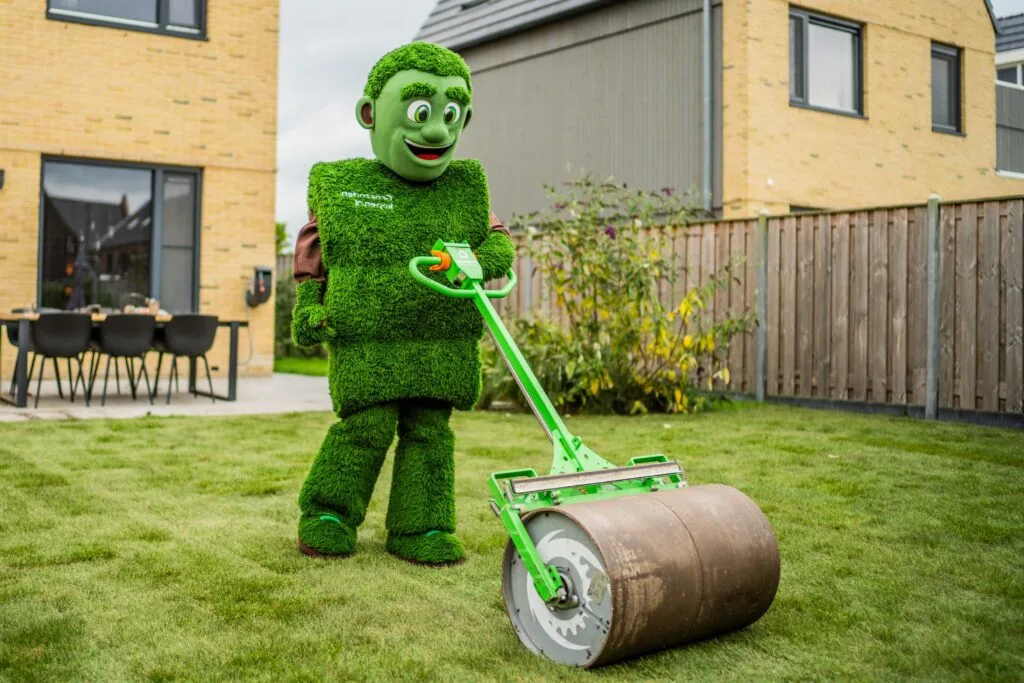 Grasmattie rolt vers gelegde graszoden aan met een gazonwals voor optimale aansluiting met de bodem.