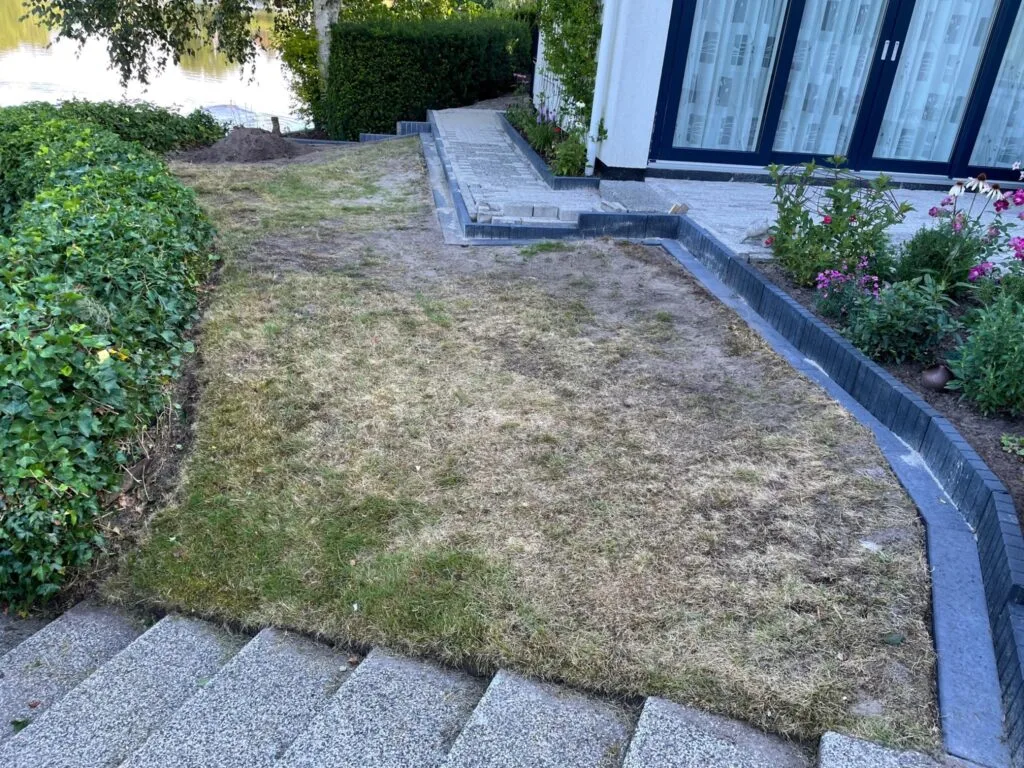Droog gazon bij terras en trap