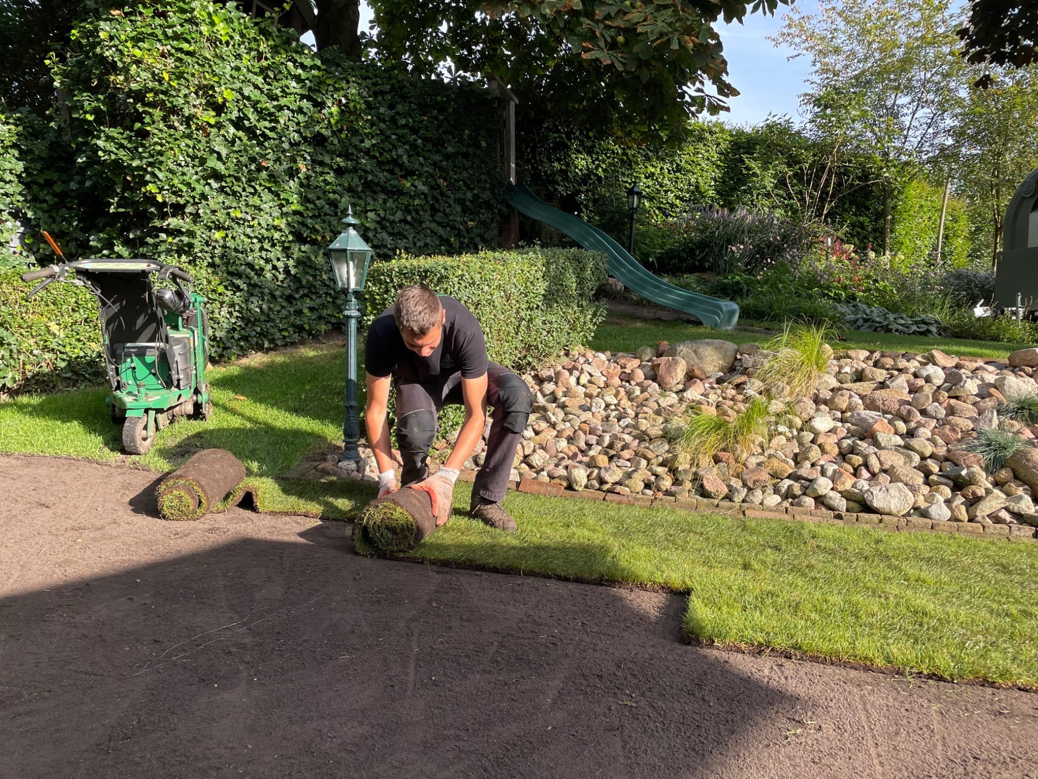 Graszoden worden door een hovenier in de trouwtuin bij De Kruimel aangelegd