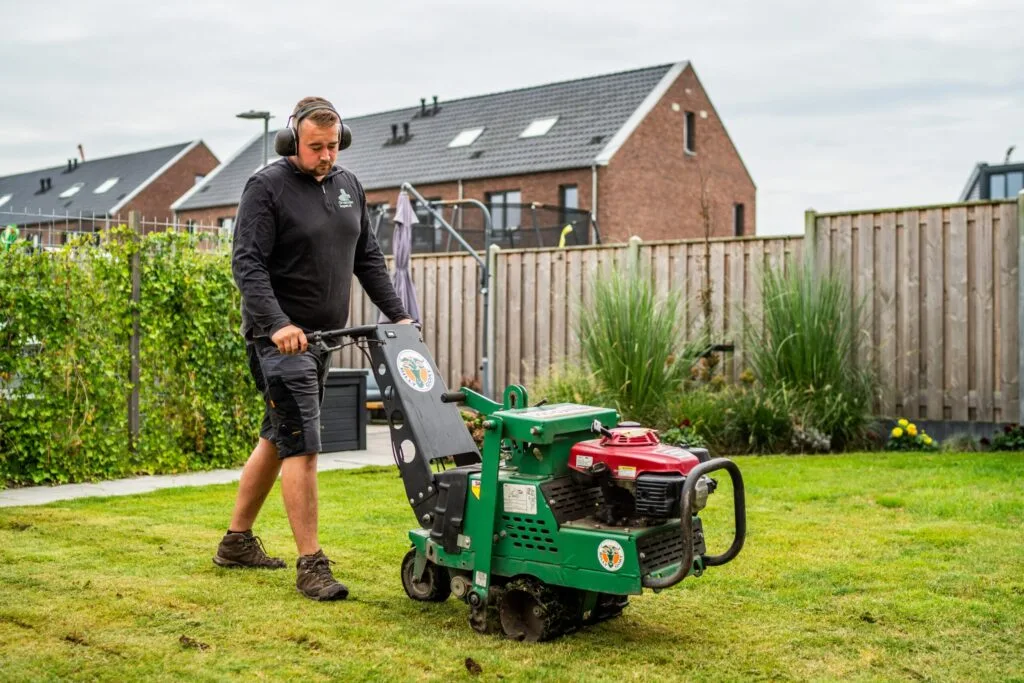 Medewerker van Graszodenkopen.nl verwijdert oud gras met een snijmachine als voorbereiding op het leggen van nieuwe graszoden.