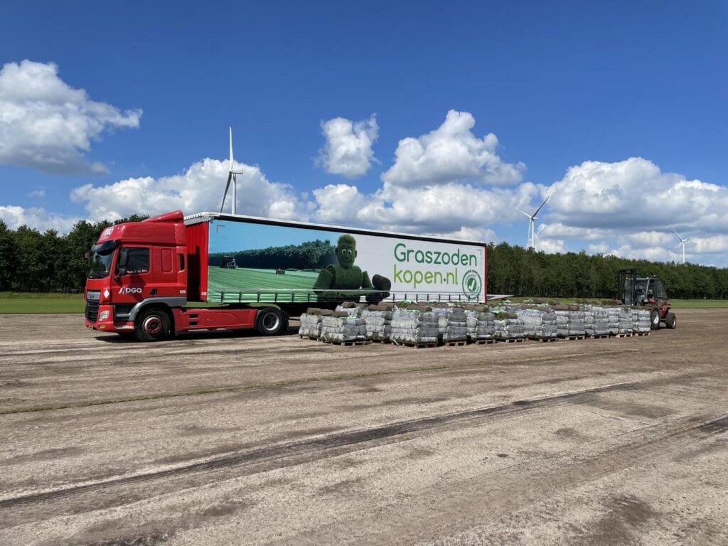 Rode vrachtwagen van DGO wordt geladen met graszoden