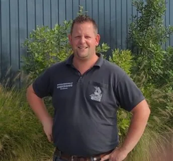 Hovenier bij een nieuw aangelegd gazon in een tuin