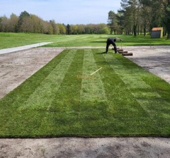 Greenkeeper legt nieuwe graszoden op een tee van Golfbaan de Semslanden