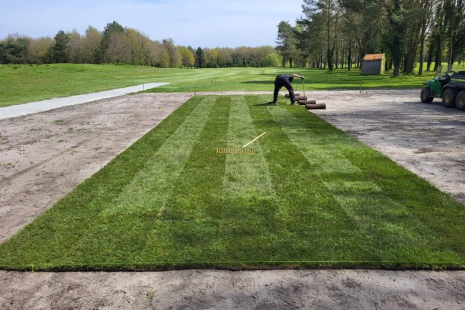 Greenkeeper legt nieuwe graszoden op een tee van Golfbaan de Semslanden